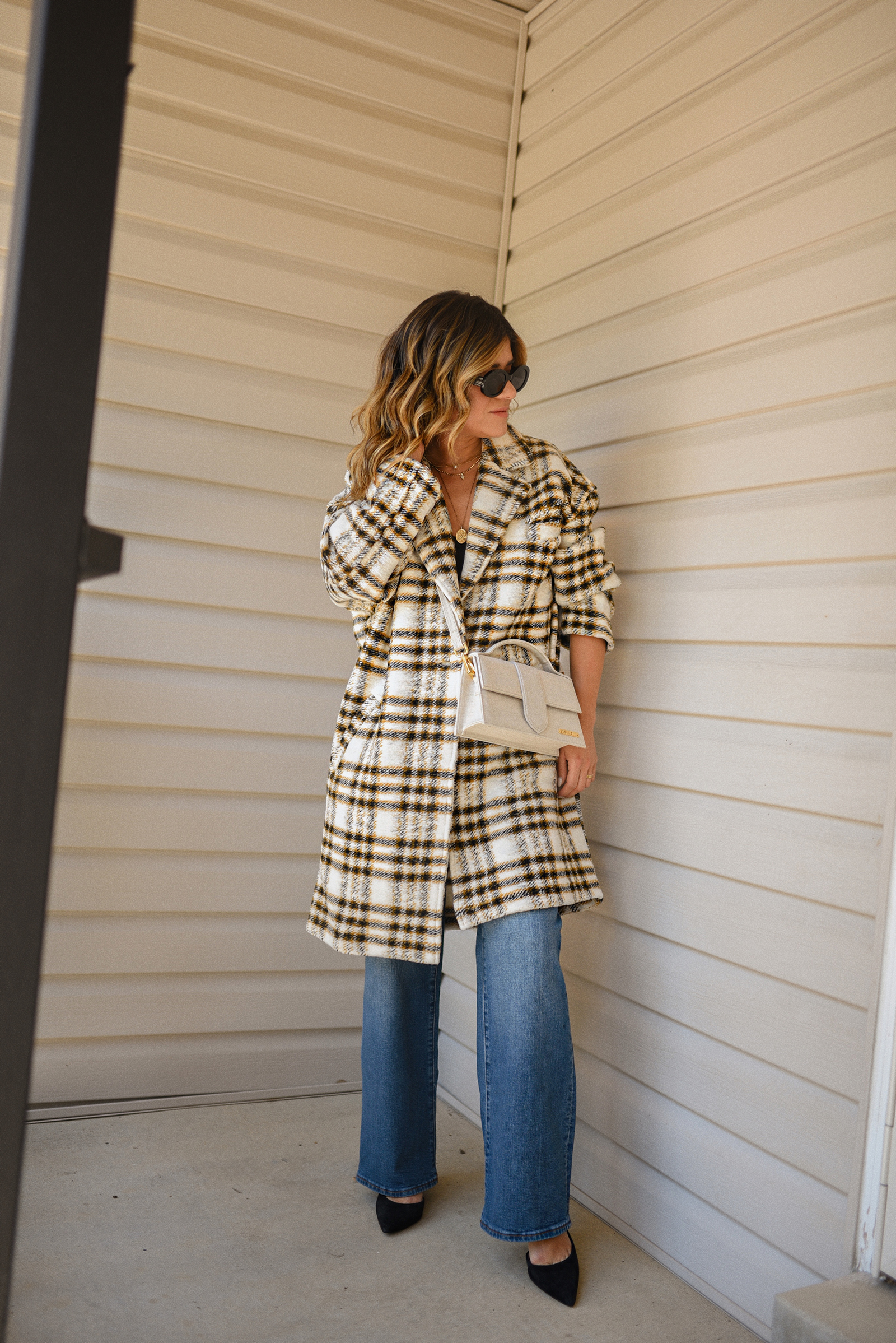 Carolina Hellal of Chic Talk wearing a Nordstrom plaid coat, Madewell wide leg jeans, Celine sunglasses, and Jacquemus Le grand Bambino Bag.